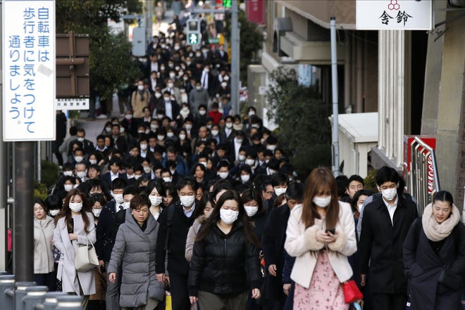 Many people wear masks as they commute during the morning rush hour last Thursday in the Chuo district of Tokyo. A viral outbreak that began in China has infected more than 75,000 people globally. As of Tuesday, more than 1,000 cases had been confirmed outside mainland China, most stemming from a cruise ship quarantined at a Japanese port. [AP / Kiichiro Sato]