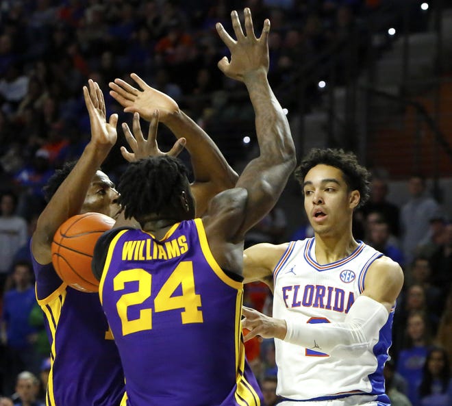Florida's Andrew Nembhard passes the ball between two LSU defenders during last year’s game in the O’Connell Center. Florida lost to LSU 79-78 in overtime. [Brad McClenny/Staff photographer]