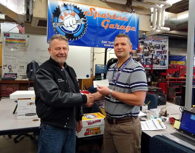 Mohican Model A Ford Club vice-president DeVerne Breed, left, recently presented a donation check to teacher Ryan Beckley of the Automotive Department at East Syracuse Minoa High School. The donation will be used to support their automotive projects and help out a few students to purchase their 2020 team shirt. [COURTESY MABEL SILLIMAN]