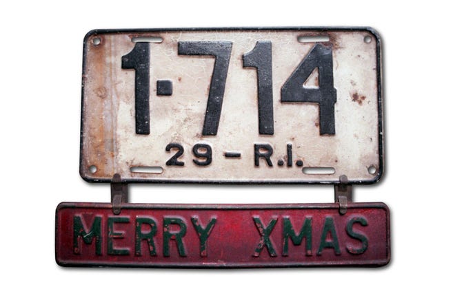 An early incarnation of a bumper sticker hangs from a 1929 Rhode Island license plate from the collection of Richard Dragon, of Warwick. Dragon, who has 7,500 plates in his collection, specializes in collecting Rhode Island plates. [The Providence Journal, file / Denise J.R. Bass]