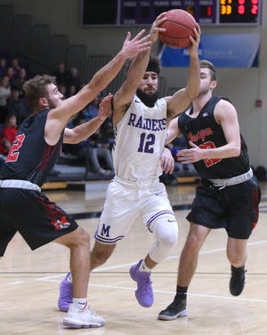Mount Union's Nathan Bower-Malone (12) tries to split the defense of Muskingum's Alex Masinelli (left) and Noah Begue during the first half of their game at Mount Union on Wednesday, Feb. 5, 2020. (CantonRep.com / Scott Heckel)