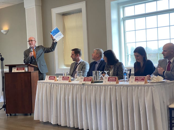 Moderator Robert Cox, far left, holds up a copy of the recently released state traffic congestion report Thursday at a forum on transportation at Marlboro Country Club. [Daily News and Wicked Local Staff Photo / Jeff Malachowski]