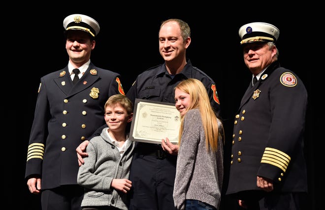 Graduate Jason Kilmer, center, and his family pose for a photo with Boxford Fire Chief Brian Geiger, left, and State Fire Marshal Peter Ostroskey, right, at the graduation of Call/Volunteer Recruit Firefighter Class #81 held inside the Masconomet Regional Middle School on Thursday, Feb. 27, 2020. [Wicked Local Staff Photo / David Sokol]