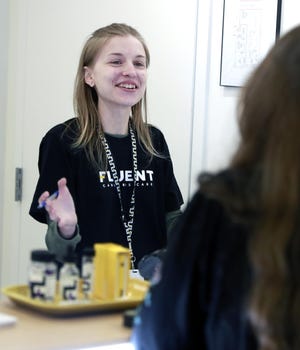 Fluent employee Amy Adams chats with a customer. Fluent Cannabis Care held their grand opening on Thursday. [PATTI BLAKE/ THE NEWS HERALD]