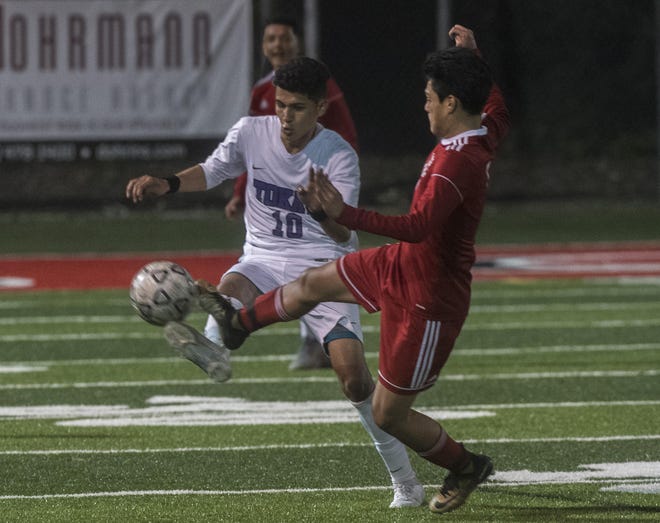 Tokay's Jose Contreras, left, fights for the ball with Lincoln's Oscar Baltazar during a boys varsity soccer game at Lincoln in Stockton. [CLIFFORD OTO/THE STOCKTON RECORD]