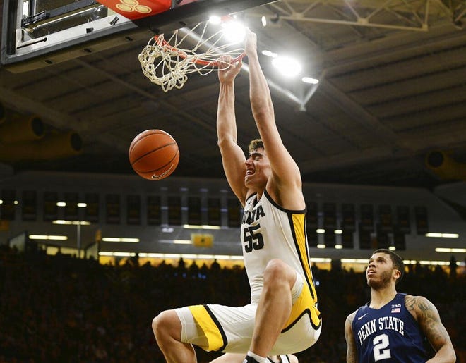 Iowa's Luka Garza (55) dunks the ball as Penn State's Myles Dread (2) looks on during the game Saturday in Iowa City. [Cliff Jette/The Associated Press]