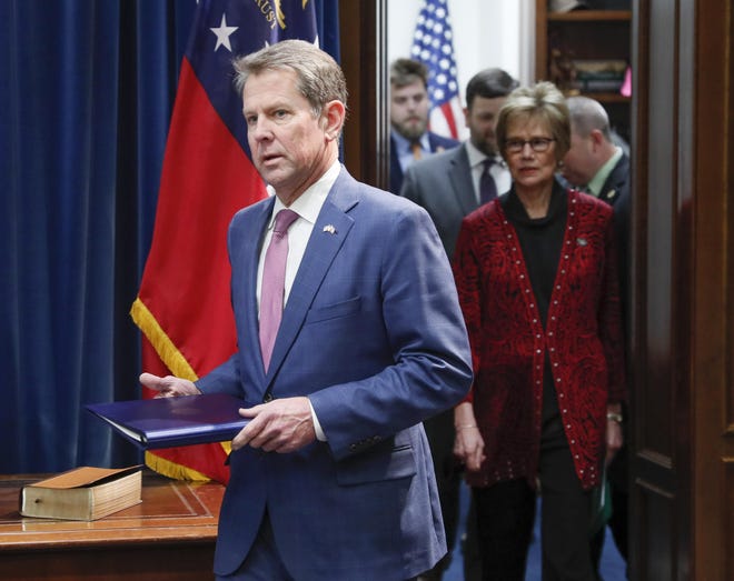 Georgia Governor Brian Kemp leads Georgia Department of Public Health Commissioner, Dr. Kathleen Toomey, into a media briefing Friday, Feb. 28, 2020, in Atlanta, regarding the creation of the Governor's Coronavirus Task Force. (Bob Andres/Atlanta Journal-Constitution via AP)