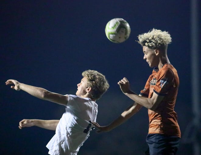 Vandegrift's Brendon Busker tries to head the ball in front of Westwood's Cedar Frias during a District 13-6A match March 3 at Westwood High School. The Warriors won 2-1 to move closer to Vandegrift in the district standings. [PAUL KNIGHT/FOR STATESMAN]