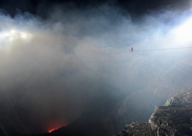 Nik Wallenda traverses a wire during the “Volcano Live!” event that was nationally televised on ABC Wednesday evening. His steel cable spanned 1,800 feet across Nicaragua’s Masaya volcano and its lake of fire, bubbling some 1,800 feet below. The feat was Wallenda’s highest and longest wirewalk to date. [Herald-Tribune photo / Tim Boyles]