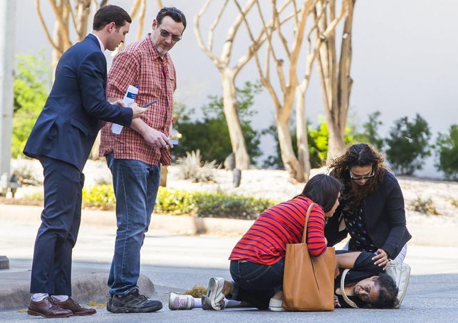 Bystanders rush to help a woman who was struck in March 2019 by a vehicle in a crosswalk at Brazos and Cesar Chavez streets in downtown Austin. Until recent changes made by the city of Austin, drivers often paid a lower fine for “failure to yield” crashes like this, instead of facing higher fines for injuring someone. [RICARDO B. BRAZZIELL/AMERICAN-STATESMAN]