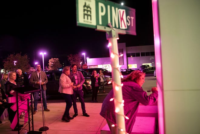 Pine2Pink founder Keith Fenimore gathers with his mother, Marianne Fenimore, a local breast cancer survivor, during a special event to honor survivors. The community came together beneath the glow of pink lights at the Pine2Pink event at Thompson Toyota, which turned its dealership pink and created a "wall of honor" to support breast cancer patients in treatment. [MARION CALLAHAN / STAFF PHOTOJOURNALIST]