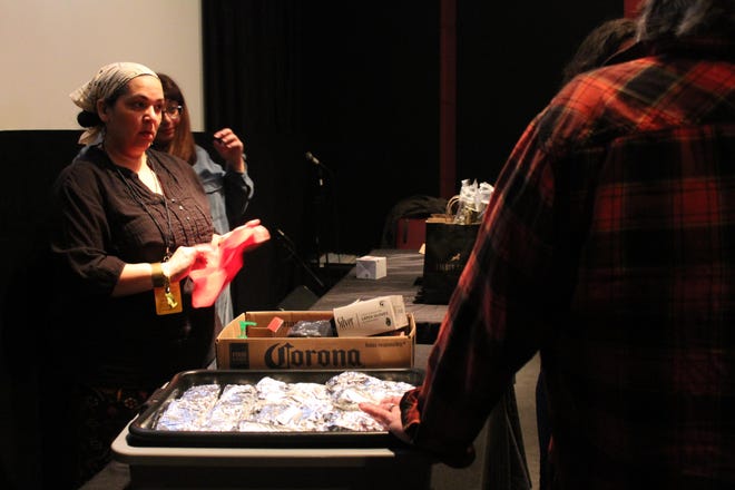 Team lead Mandy Mooney packs up leftover burritos as Weird Wake-Up attendees prepare to end breakfast and enter the film that followed. [Elena K. Cruz/Tribune]