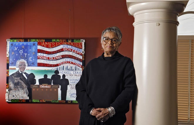 Bettye Stull, curator of the exhibit "Preserving the Legacy: James Preston Poindexter“ at the Broad Street Presbyterian Church, shown with "Poindexter for the People" by artist Shelbi Harris-Roseboro. [Eric Albrecht/Dispatch]