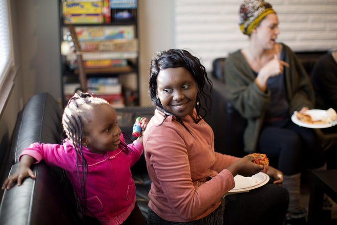 Eve Cohmer, of Gahanna, with her 3-year-old daughter, Diana, talks with other single moms during a community dinner hosted by Motherful on Feb. 4. At the dinners, mothers can share their stories with like-minded people and get help with their families’ daily needs. [Courtney Hergesheimer/Dispatch]