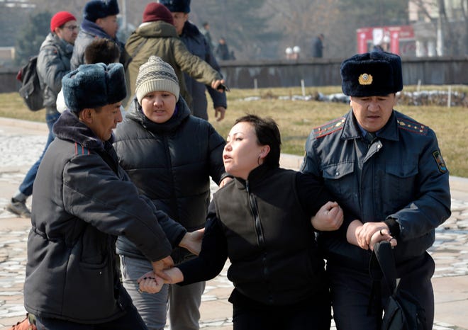 Kyrgyz policemen detain an activist of the Femen women's rights movement at Victory Square during celebration of the International Women's Day in Bishkek, Kyrgyzstan, Sunday, March 8, 2020. (AP Photo/Vladimir Voronin)