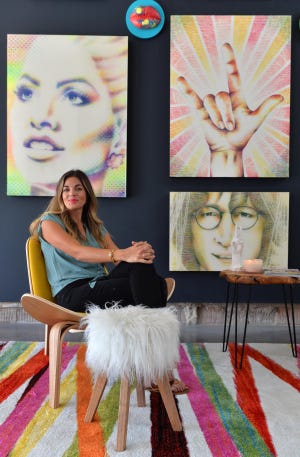 Alexis Fraser, known as Lipstick Lex, sits in her art gallery in the Rosemary District where she is creating and selling paintings she makes solely from lipstick. [HERALD-TRIBUNE STAFF PHOTO / MIKE LANG]