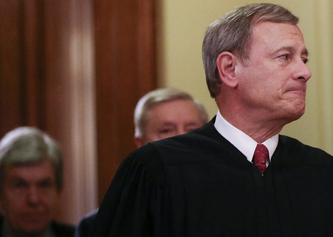Supreme Court Chief Justice John Roberts, right, departs the Senate chamber along with Sen. Lindsey Graham (R-S.C.), middle, and Sen. Roy Blunt (R-Mo.) after the Senate impeachment trial of President Donald Trump concluded on February 5, 2020, in Washington, D.C. (Mario Tama/Getty Images/TNS)