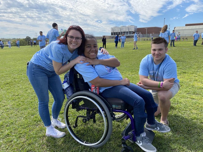 Mimi Copeland, left, and Cayden Cork, left, hang out with friend Kennedy Thompson during a field day hosted by Lake Minneola High School Student Government Association students for the special needs students in the Access and ESE programs as a way of promoting inclusiveness and celebrating their “One-Hawk” motto campus-wide. [Roxanne Brown/Daily Commercial]