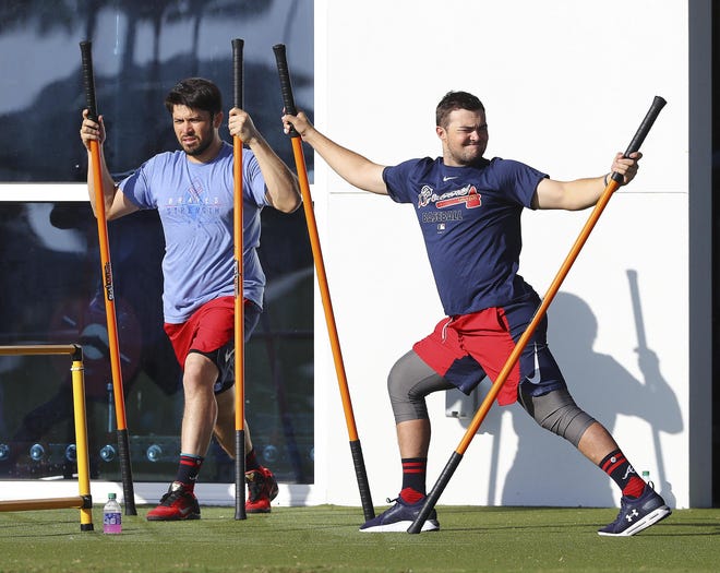 Atlanta Braves catchers Travis d’Arnaud (left) and Shea Langeliers do drills on the agility field to loosen up for spring training on Feb. 16 in North Port, Florida. [CURTIS COMPTON/ATLANTA JOURNAL-CONSTITUTION VIA AP]