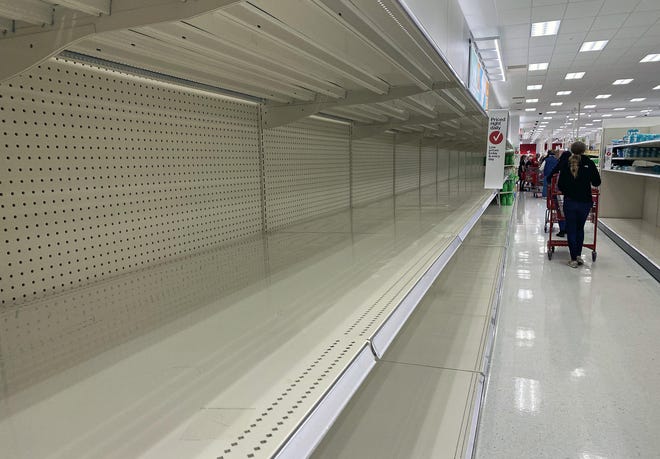 A customer looking for toilet paper finds empty shelves Thursday at the Target store in Hilliard. [Kyle Robertson/Dispatch]