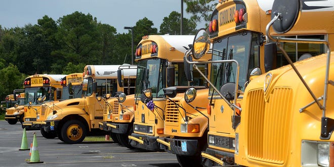 Some of the St. Johns County School District's buses sit in their transportation department's lot. [Record file]