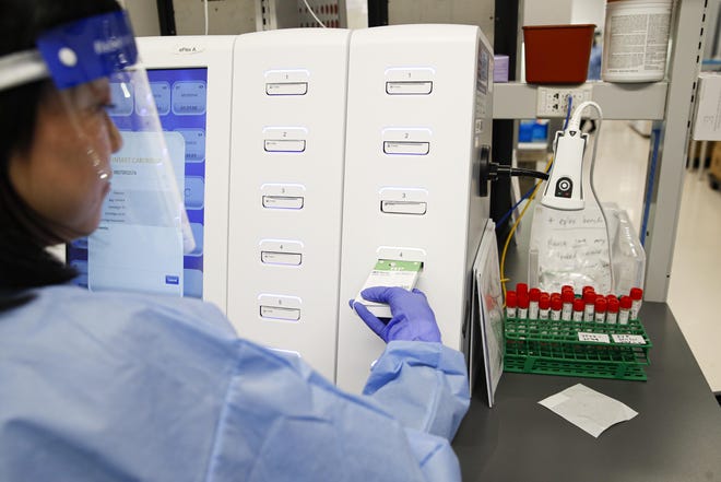 A laboratory technician prepares COVID-19 patient samples for semi-automatic testing Wednesday at Northwell Health Labs in Lake Success, N.Y. [AP Photo/John Minchillo]