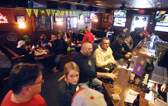 Customers eat and drink at Schooners, in Bloomington, Sunday, March 3, 2020, after Illinois Gov. JB Pritzker announced that dine-in service would be halted in restaurants and bars across Illinois. (David Proeber/The Pantagraph via AP)