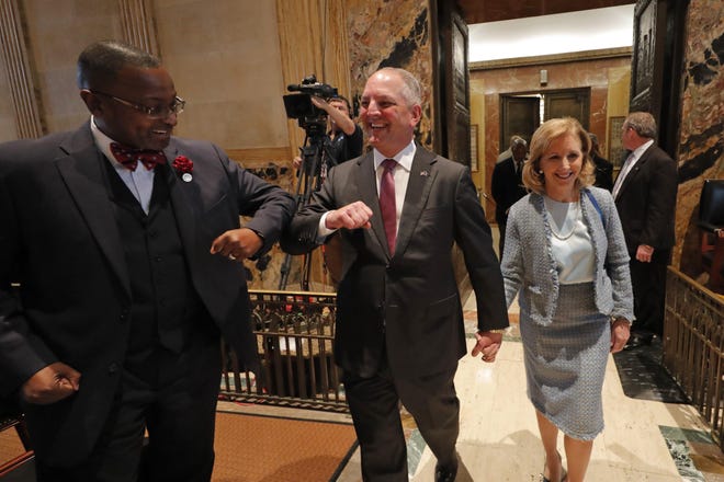 Louisiana Gov. John Bel Edwards, center, bumps elbows with state Rep. Patrick Jefferson, D-Homer, as a precaution against the coronavirus, as he walks down the aisle of the House Chambers for the opening of the 2020 general legislative session in Baton Rouge, La., March 9. [AP PHOTO/GERALD HERBERT]