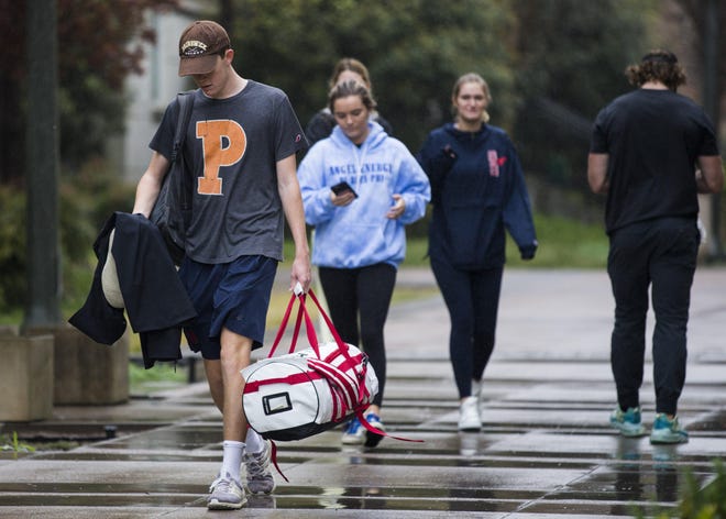 Southern Methodist University students leave campus before Spring Break on Friday. Over the weekend, Texas Gov. Greg Abbott waived regulations to ensure students in work-study programs continue to receive funding while universities scale back operations. [Ashley Landis/The Dallas Morning News via AP]
