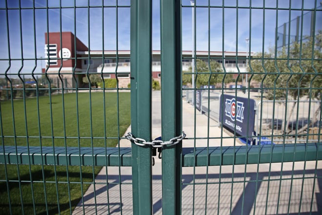 A gate at the Chicago Cubs’ practice facility at Sloan Park in Mesa, Ariz., is locked Monday. Spring training games have been canceled because of the coronavirus pandemic. [Sue Ogrocki/The Associated Press]