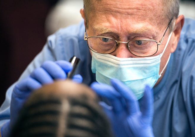Dentist Gary Herbert from the Peoria City/County Health Department dental program does an examination as the Give Kids A Smile program makes a visit to Crittenton Centers in a file photo. [FRED ZWICKY/JOURNAL STAR]