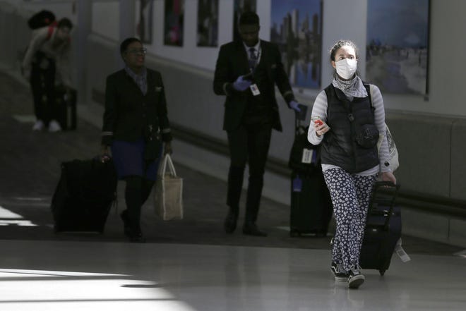 In this photo, air passengers leave a customs area at Newark Liberty International Airport in Newark, N.J., Sunday, March 15, 2020. [AP Photo/Seth Wenig]

Natick resident Roesli Arena who was traveling in Europe had to be resourceful to return to the United States. She booked a flight from Switzerland to Newark N.J. and endured hours of waiting to be screened by health officials.

 "It's been fine so far," said Arena in a phone interview Monday from her Natick home. "I'm happy to be home after being so worried for so long. But I will probably go stir-crazy a few days from now."