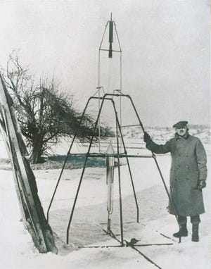 Dr. Robert H. Goddard is shown standing with the world's first liquid-propelled rocket March 16, 1926, at Auburn, Massachusetts. When launched, the rocket soared 41 feet high and carried 184 feet in two and one half seconds. It moved at 60 miles an hour. [THE ASSOCIATED PRESS]
