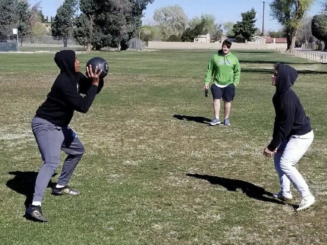 Apple Valley football players Jayden Max Denegal, left, and Steven Wright, right, pass a weighted ball to each other during a workout at a local park on Tuesday. [Photo courtesy of Jayden Denegal]
