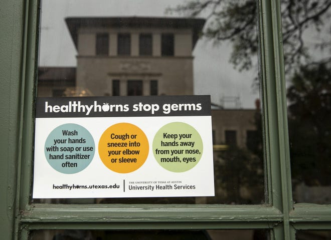 A sign instructs how to stop germs at an entrance to the School of Architecture building at UT on Monday March 9, during a coronavirus scare. [JAY JANNER/AMERICAN-STATESMAN]