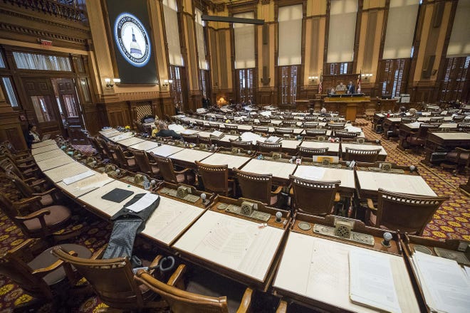 Empty rows of desks are seen in the House chambers during the Georgia legislative session on Friday, March 13, 2020, in Atlanta. [Alyssa Pointer/Atlanta Journal-Constitution via AP]