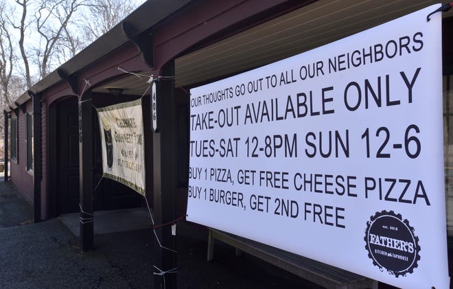 Father's Kitchen and Taphouse in Sandwich makes takeout information clear on a banner put up outside the Route 6A restaurant. [STEVE HEASLIP/CAPE COD TIMES]
