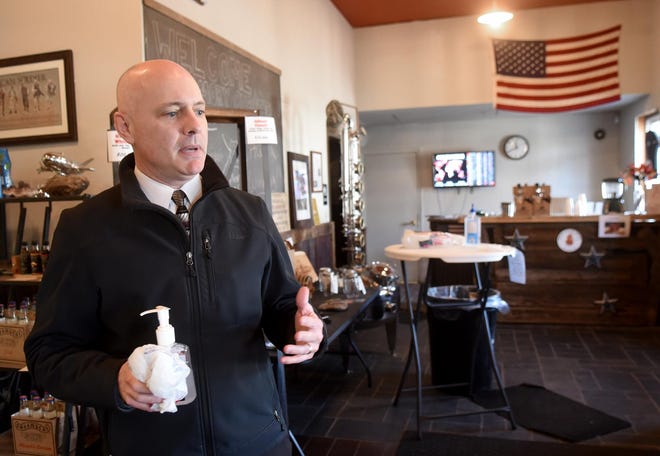 Mike Ashton, who lives in Somersworth and works in Hampton, stopped in at Smoky Quartz Distillery in Seabrook to get 8 ounces of free hand sanitizer created from an alcohol base during the shortage. [Deb Cram/Seacoastonline]