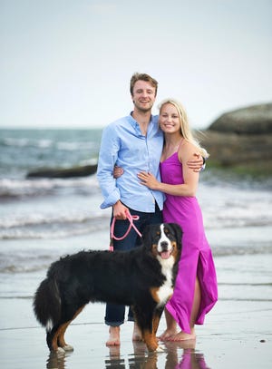 Jamie Hodnett and Conor Kelly pose with their dog Jennings on Easton’s Beach in Newport during their engagement shoot. The couple was to be married in Newport on April 4, but because of the coronavirus pandemic, the wedding date has been shifted to July 5. [SUSAN SANCOMB PHOTOGRAPHY]