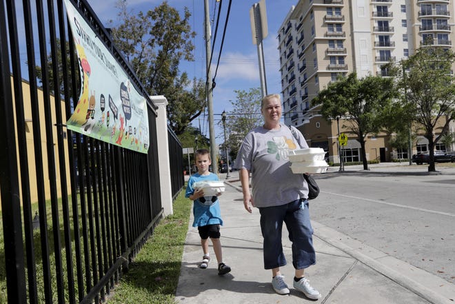A 6-year-old boy and his mother leave an elementary school in Miami on Monday. [Lynne Sladky/The Associated Press]