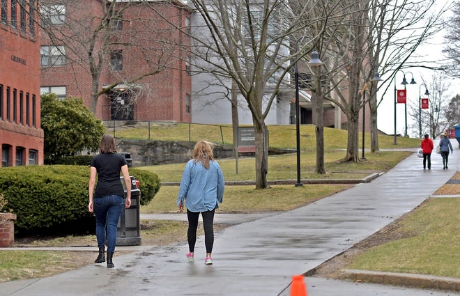 Students walk across the Clark University campus Friday, as colleges transition from in-person to remote learning in response to coronavirus. [T&G Staff/Steve Lanava]
