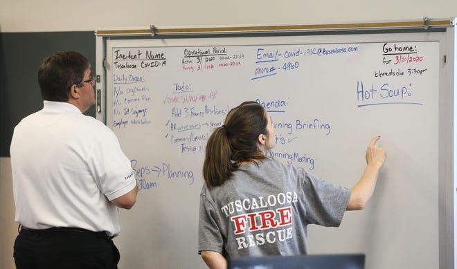 John Brook, deputy chief of administration, works at a white board with Tara Newman as they join other city leaders working to mitigate the COVID-19 situation in Tuscaloosa from the Incident Command Center that has been established in the Tuscaloosa Amphitheater Friday, March 20, 2020. [Staff Photo/Gary Cosby Jr.]
