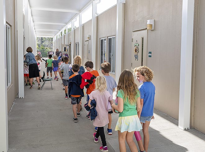 Palm Valley Academy students walk to their classroom in a row of relocatable buildings behind the school on March 12, 2020. [PETER WILLOTT/THE RECORD]