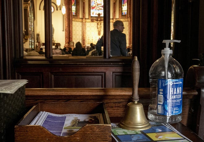 Hand sanitizer and safety information about the coronavirus greeted parishioners at the door during noon Mass at St. Mary’s Cathedral on Sunday March 15, 2020. [JAY JANNER/AMERICAN-STATESMAN]
