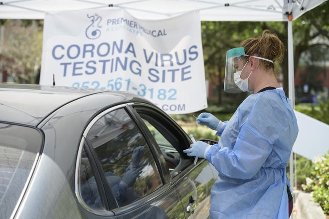 Clinical Manager Brandy Kuzara conducts drive-through testing for the coronavirus at Premier Medical Associates in The Villages on Thursday. [Cindy Sharp/Correspondent]