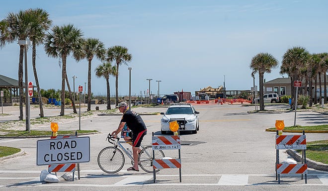 Signs block an entrance to the parking lot of the St. Johns County Ocean and Fishing Pier Park in St. Augustine Beach on Monday. The county has closed all beach parking lots because of the coronavirus. [PETER WILLOTT/THE RECORD]