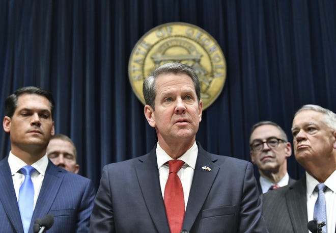 Gov. Brian Kemp speaks as other officials standing behind during a press conference to provide an update on the state's efforts regarding COVID-19, after reporting the first death in Georgia related to coronavirus, at the Georgia State Capitol on Thursday, March 12, 2020. (Hyosub Shin/Atlanta Journal-Constitution via AP)