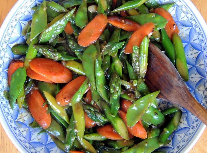 Stir-Fried Spring Vegetables (asparagus, carrots, snow peas, and scallions) can be served alone as a side dish or over rice as a vegetarian main dish. [Damon Lee Fowler/for Savannah Morning News]