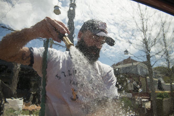 Workers wash cars at Starland Yard on Tuesday. The proceeds from the charity car wash went to the Emmaus House, a Savannah-based interfaith organization offering free breakfast, laundry and showers to anyone who needs it. [Will Peebles/Savannahnow.com]