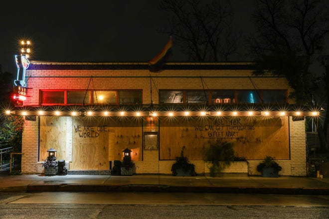 East Sixth Street, usually brimming with visitors on Saturday nights, was deserted last weekend on March 21. Travis County’s bars and restaurant dining rooms are closed and gatherings of 10 or more people are prohibited. [LOLA GOMEZ / AMERICAN-STATESMAN]